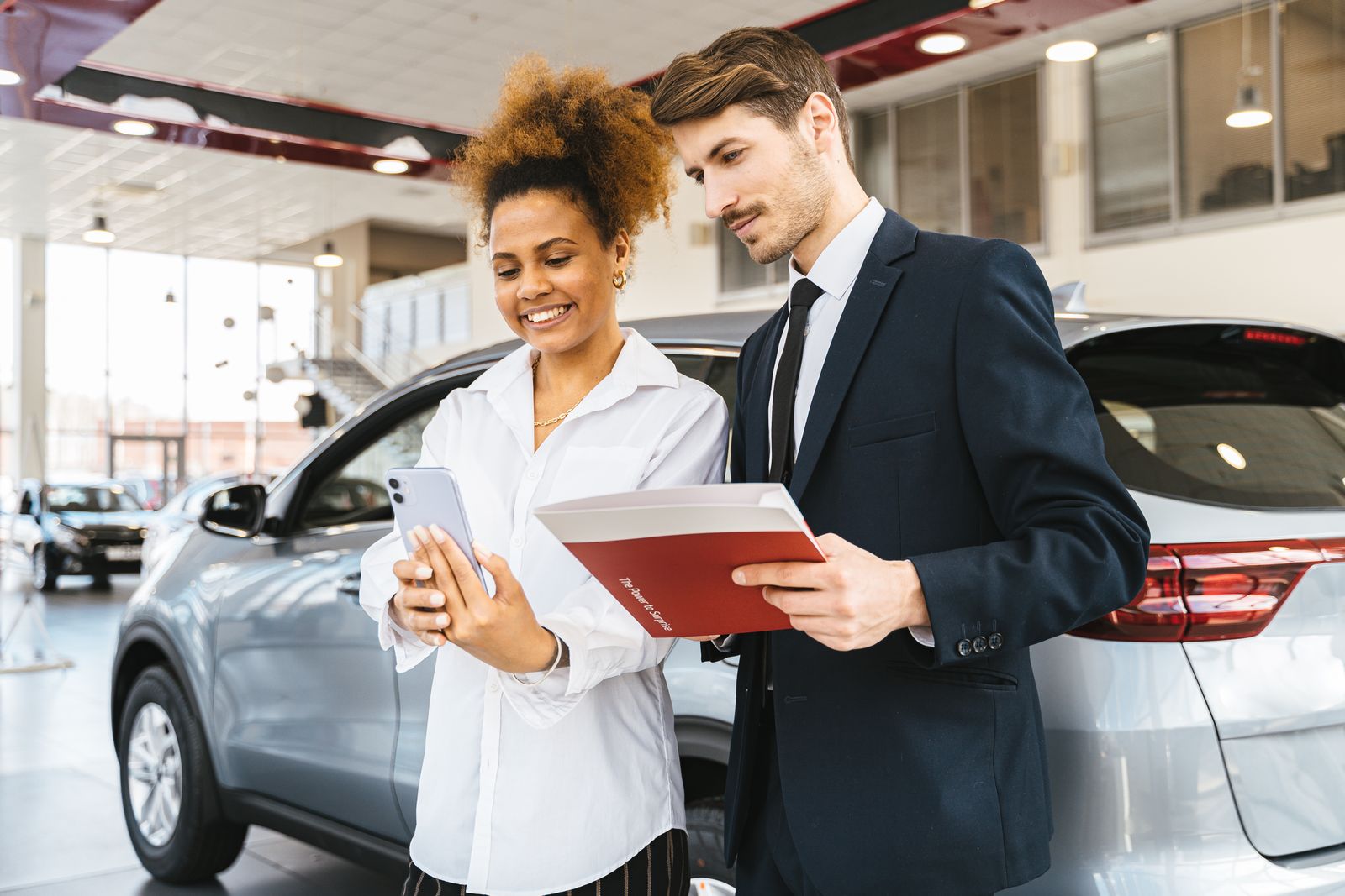 Cliente et conseiller échangeant dans un showroom automobile